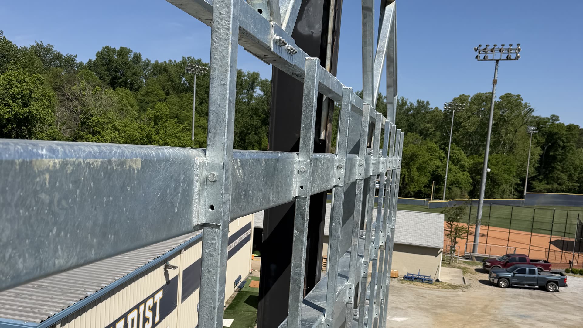 Galvanized steel scoreboard structure erected at a school athletic field under a clear sky