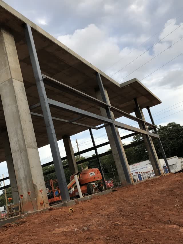 Steel columns and beams standing on red Georgia clay at an early stage of erection