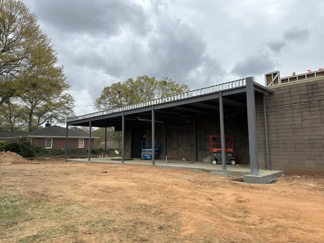 Long steel covered walkway canopy running along a building