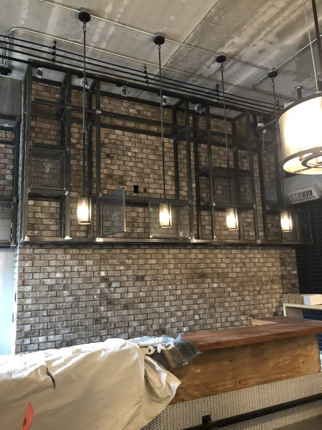 Architectural steel framing in a finished interior with pendant lighting