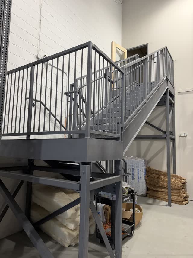 Steel mezzanine platform and access stair inside a building