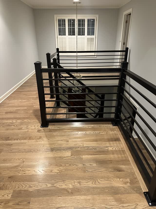 Black steel guardrail at an interior stair opening