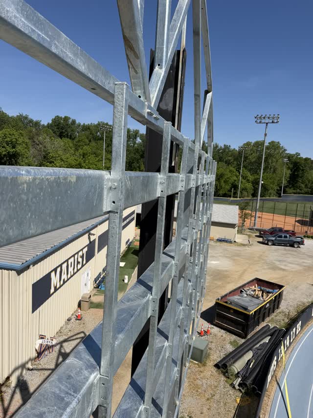 Galvanized steel structure being erected beside an athletic field