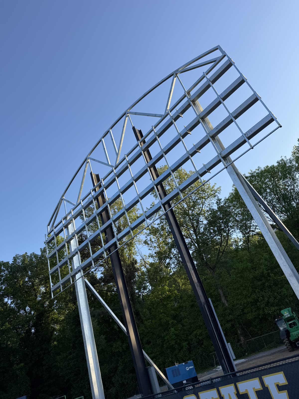 Steel scoreboard structure standing against open sky