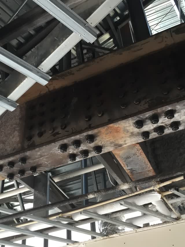 Underside of metal roof deck carried on steel beams and framing