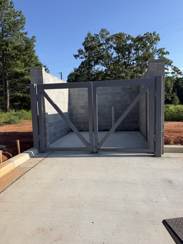 Steel drive gate installed across a concrete driveway