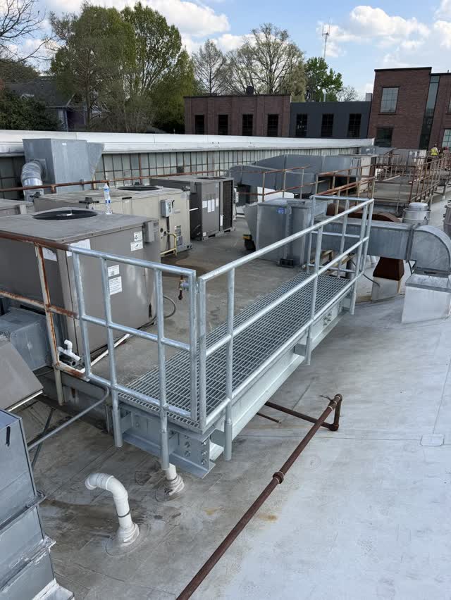 Steel rooftop equipment support platform with guardrail and pipework