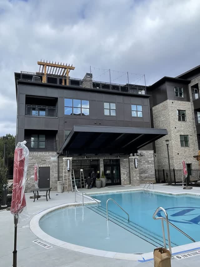 Steel canopy and amenity structure beside an apartment pool deck