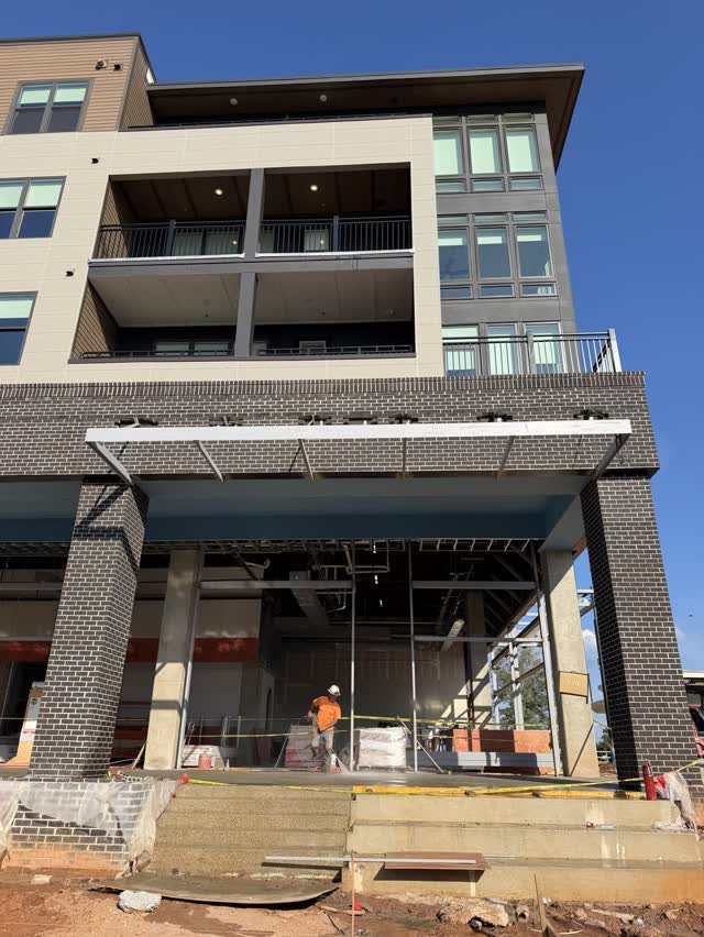 Steel retail canopy beneath the residential floors of a mixed use building