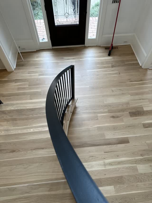 Custom curved steel handrail installed on a finished stair